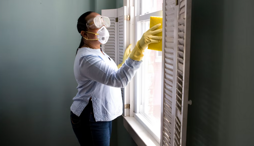 A woman with gloves and mask, cleaning the window. #sidehustles #additionalincome #earnmoney #finance