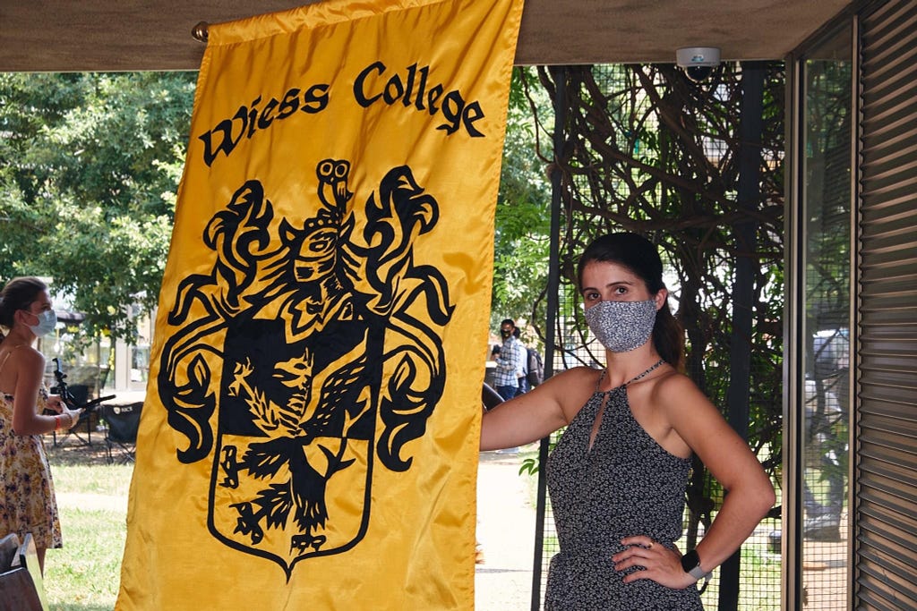 Lauren Biegel poses in a mask with the Wiess College flag.