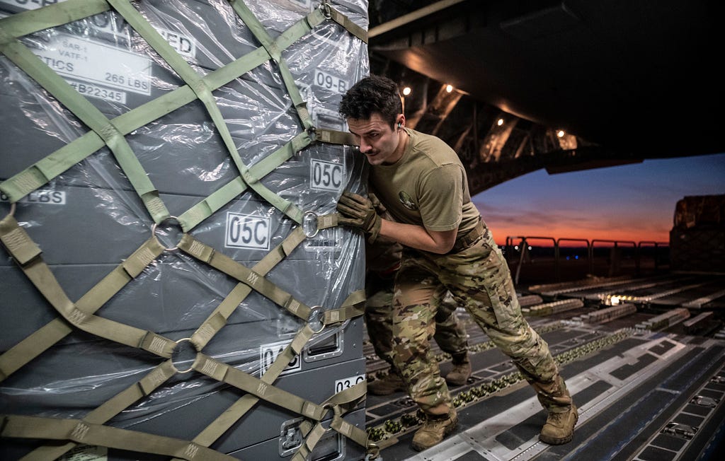 Senior Airman Garrett LaMarche, 6th Airlift Squadron loadmaster, pushes a cargo pallet onto a C-17 Globemaster III on Dover Air Force Base, Delaware, Feb. 7, 2023.