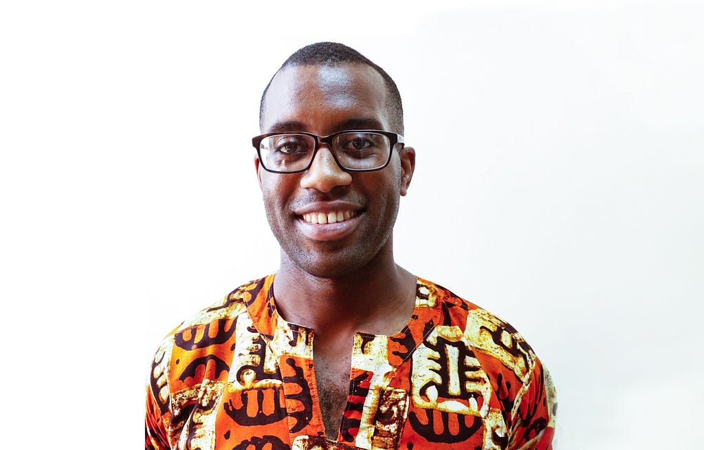 Headshot of Kelvin Hughes, smiling, in glasses.