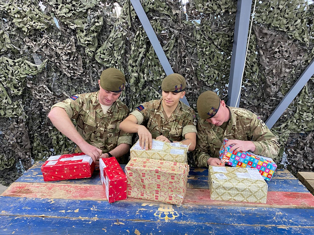 Gdsm Davies, Cassidy-Ballard, Phillips open presents donated by children from The Forest School, North Yorkshire, Erbil International Airport while on Op SHADER.