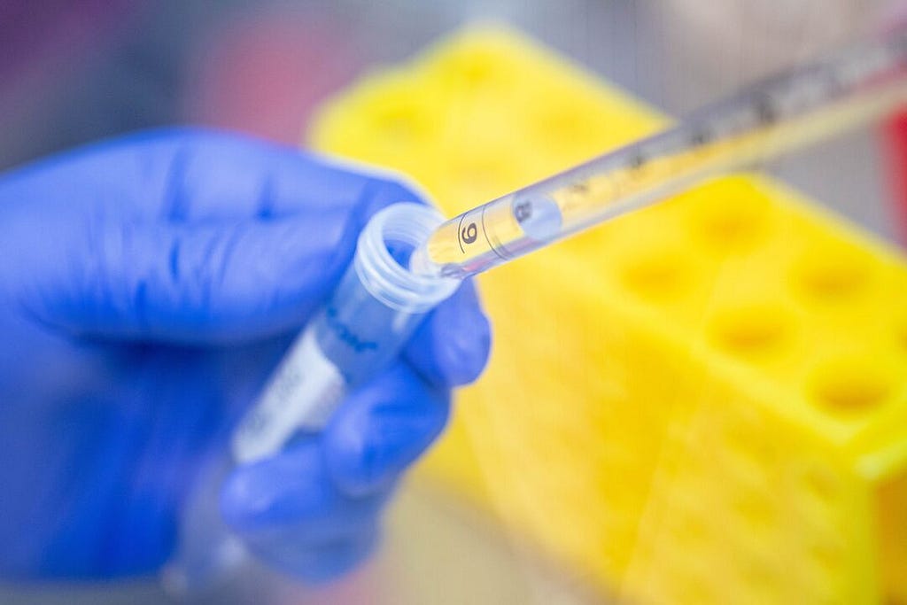 researcher puts liquid into a test tube