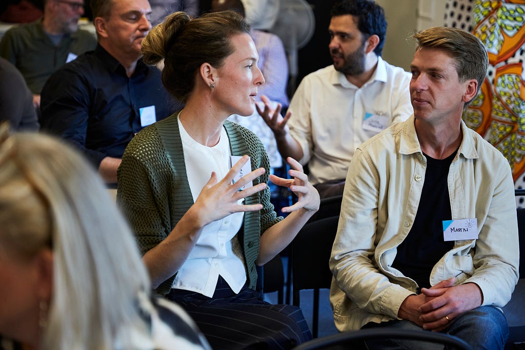 Participants sitting next to each other and in conversation at the Dela Summit 2023 in Älmhult, Sweden.