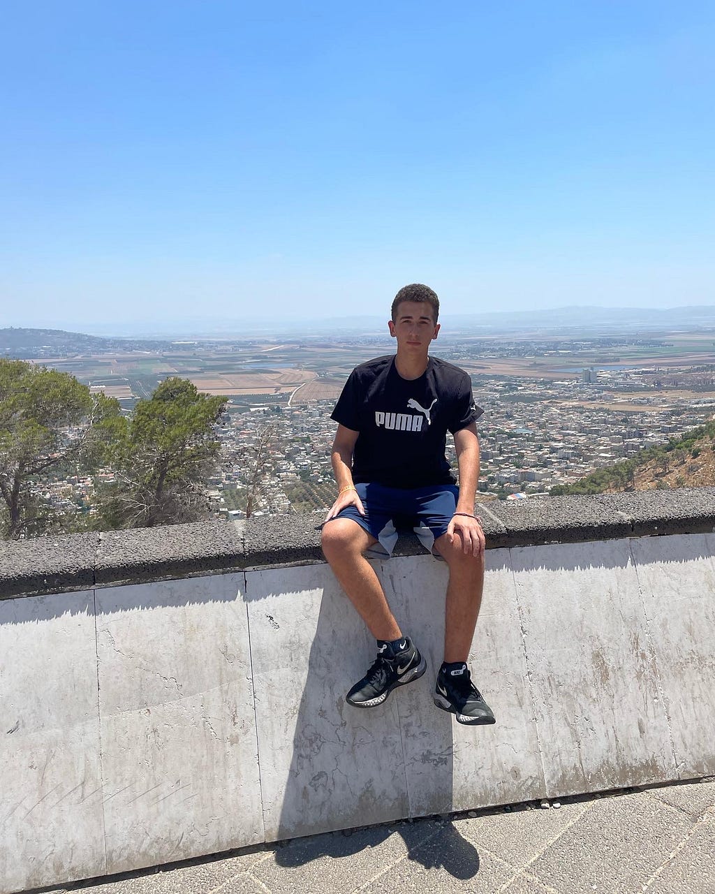 Alexander Milman sitting upon a ledge overlooking the Jordan Valley [Middle of July, 2022]