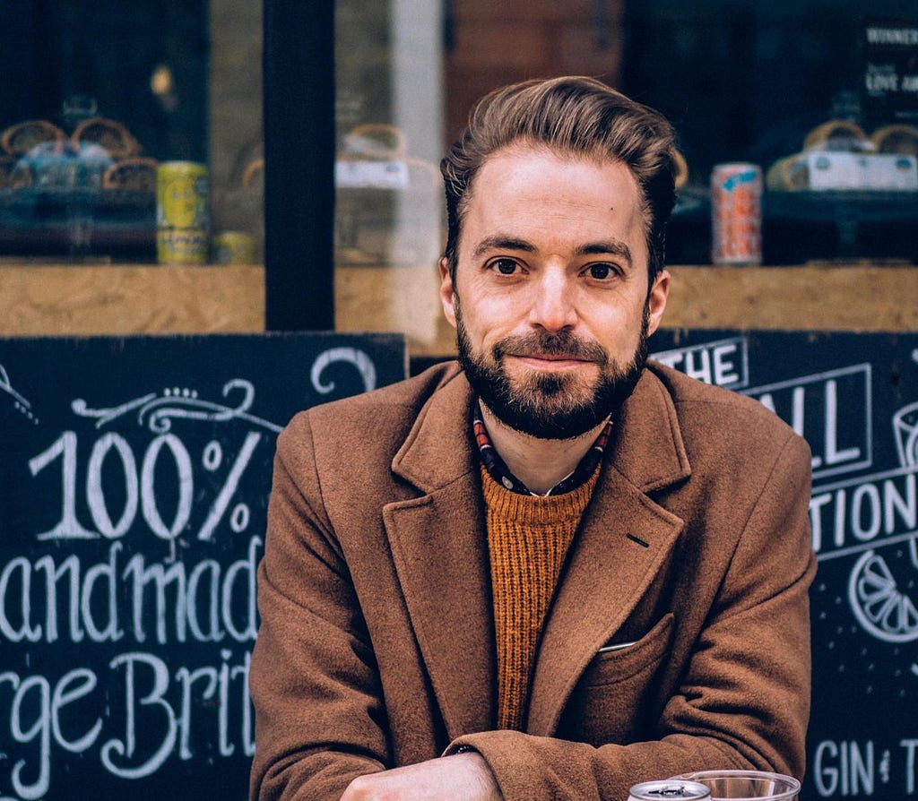 Playwright Tristan Bernays sitting outside a London pub