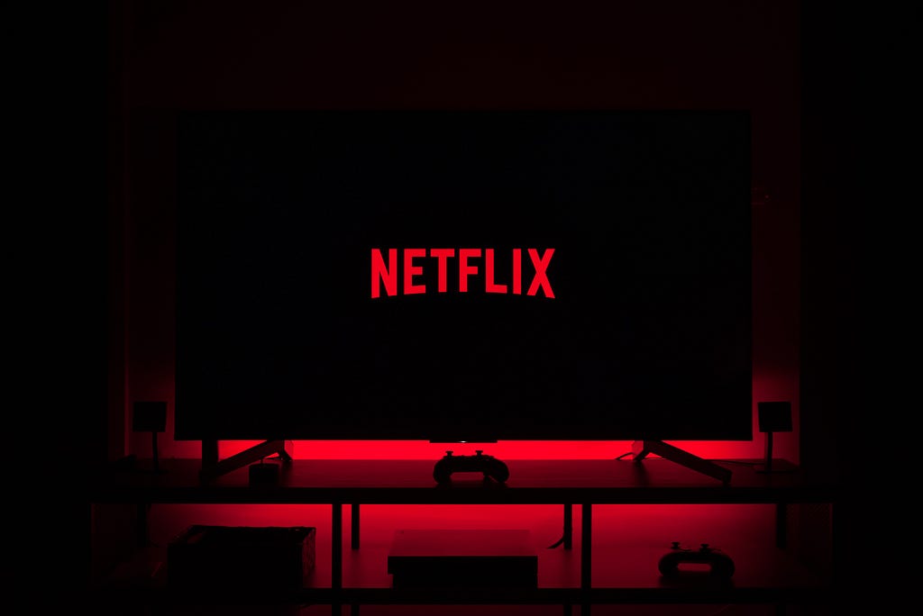 An image of TV with Netflix logo on it and red mood lighting.