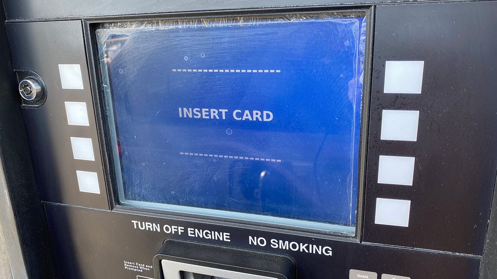 The blue payment screen at a gas pump that says to insert card