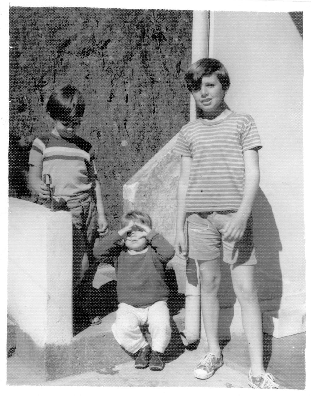 Foto em preto e branco de três crianças.