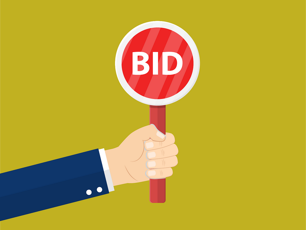A single person holding a sign that says “Bid”