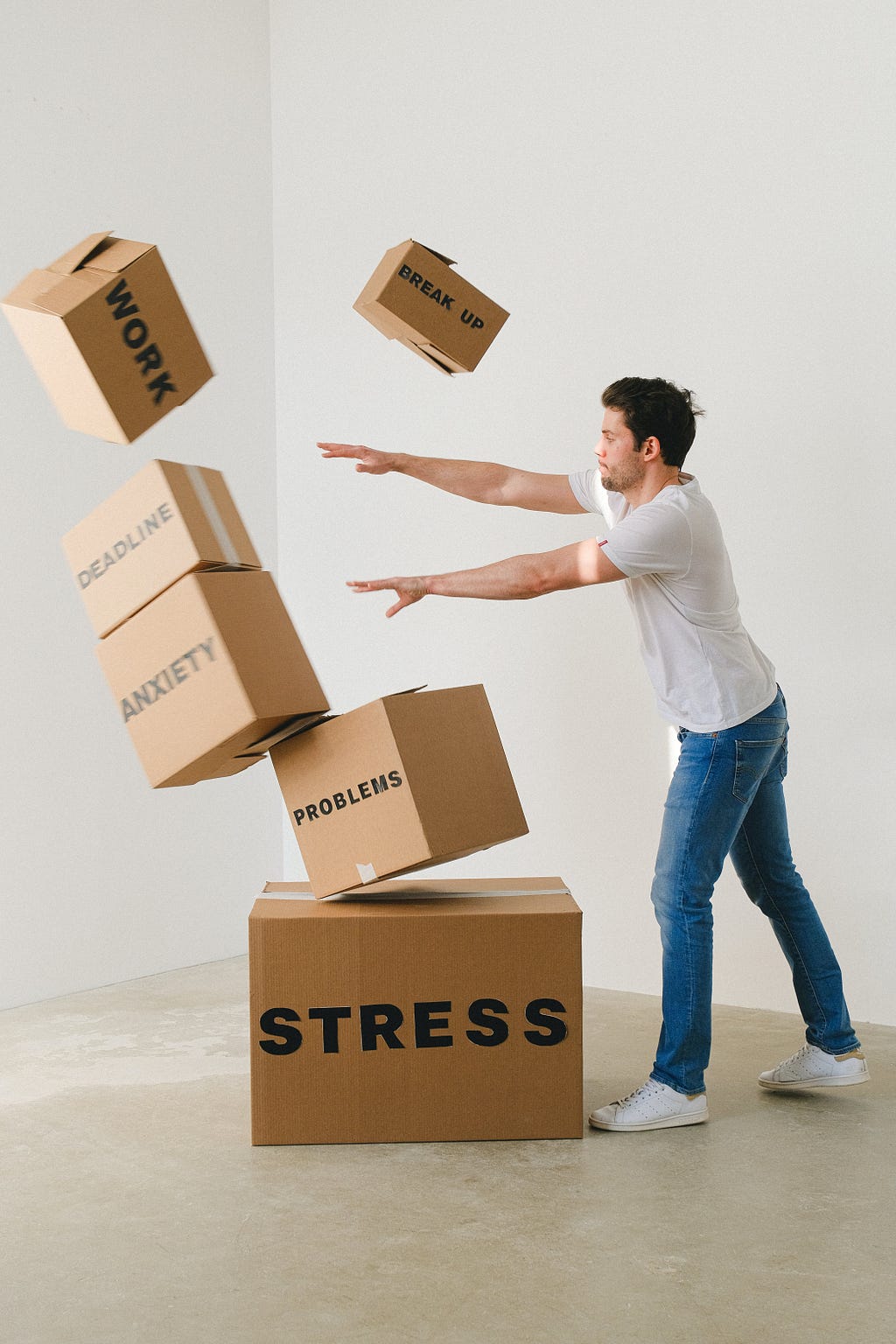 man pushing boxes named stress, anxiety, problems and deadlines