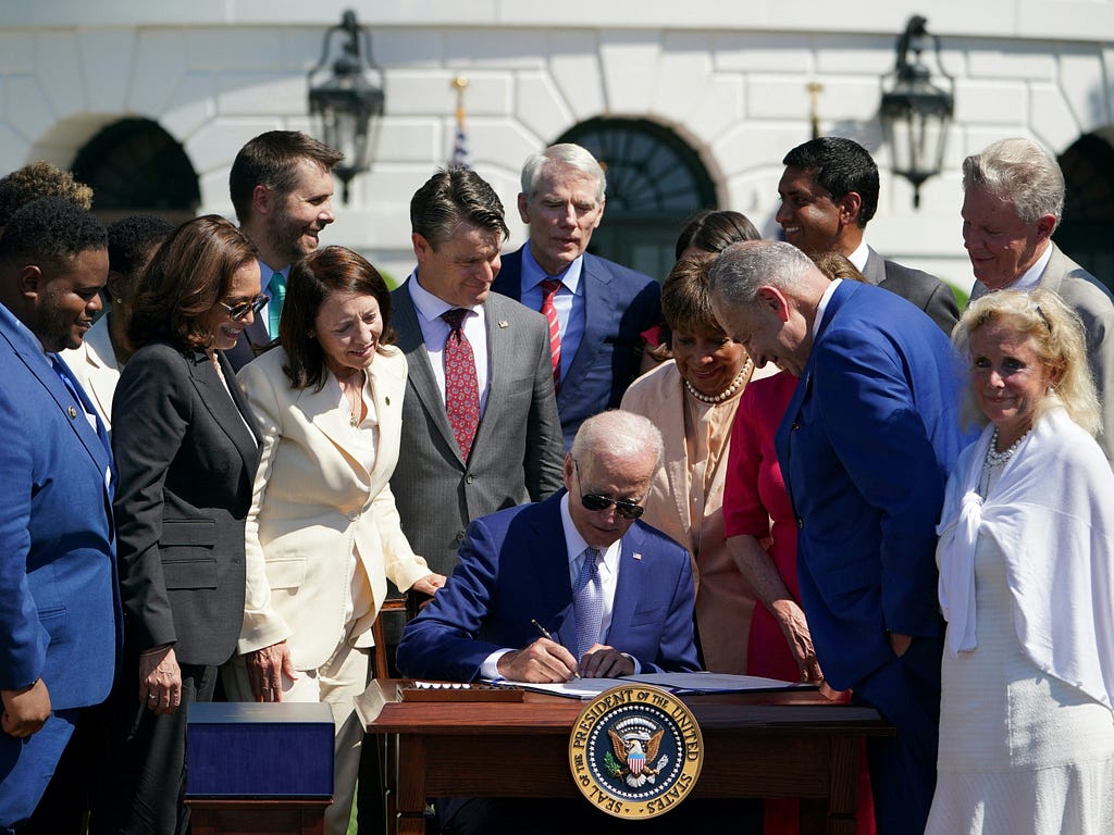 Group of lawmakers around president Biden signing bill