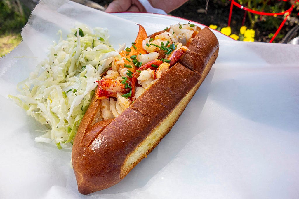 a lobster roll with a side of letuce