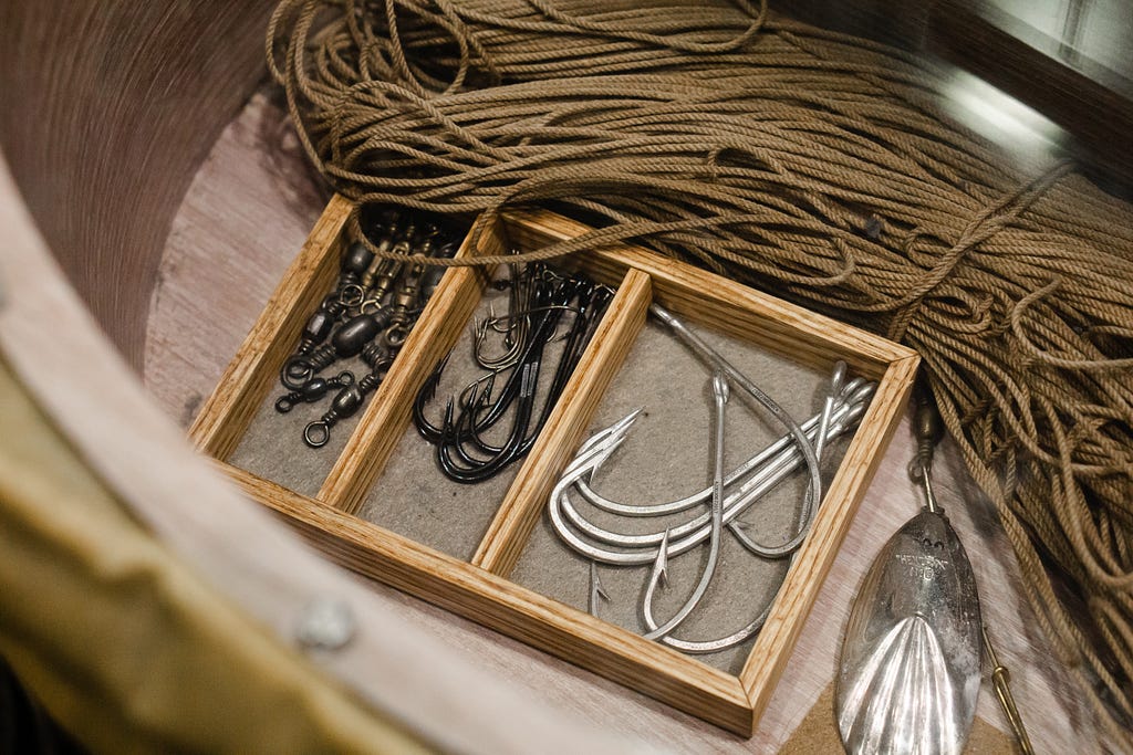 An antique box of fishing hooks and rope