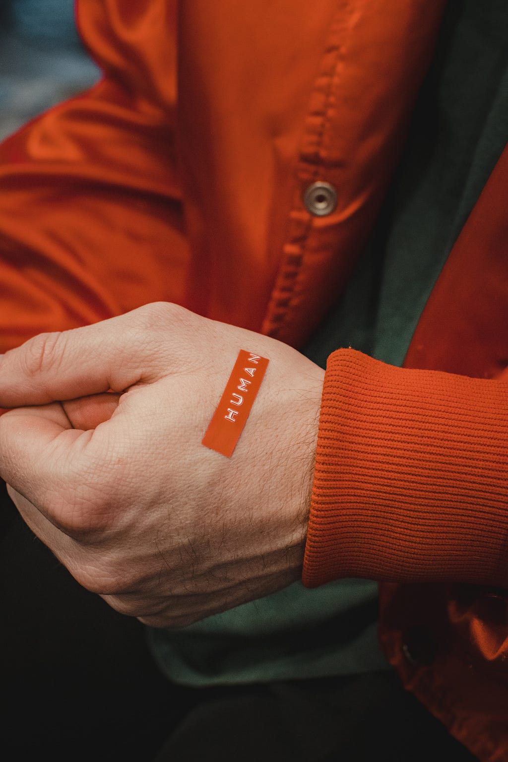 a close up of a human hand with a label “human” on the hand. the background is the person’s torso who is wearing a button down jacket