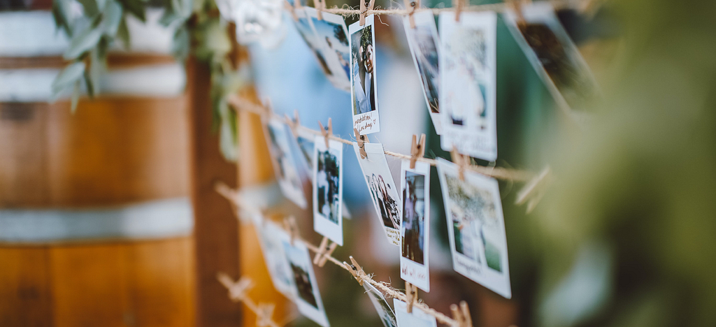 Rows of polaroid pictures clipped to strings.
