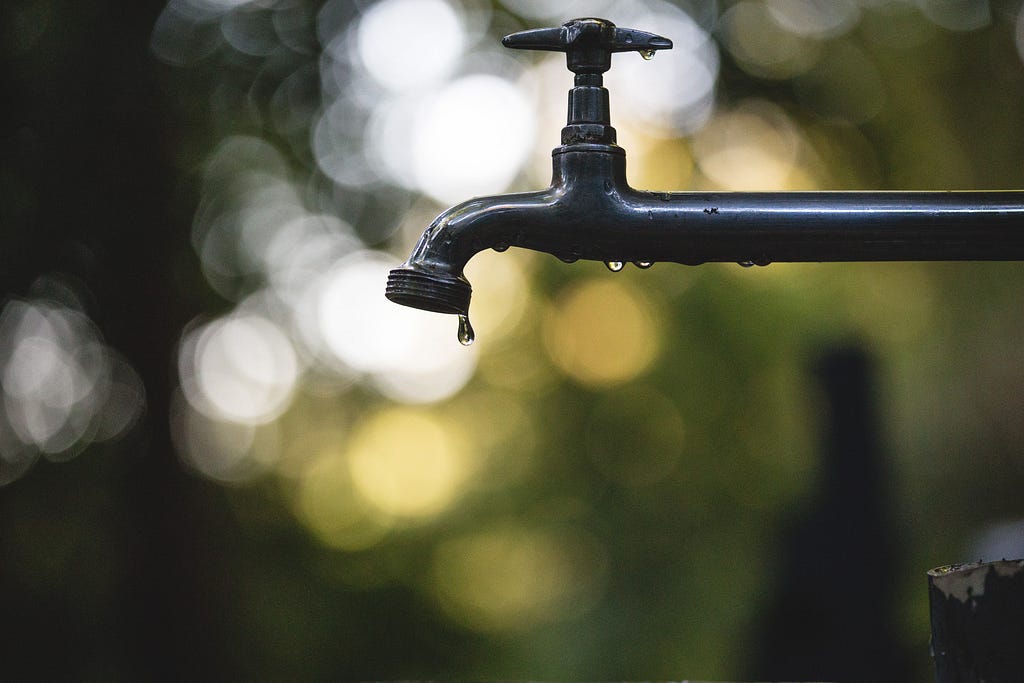 A water spigot in focus against a blurred background.