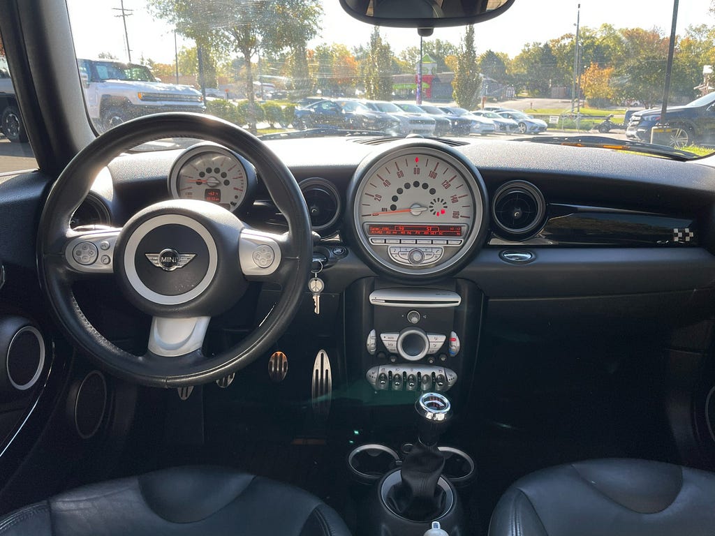 The interior of a 2009 Mini Cooper Clubman. It has a massive round speedometer and looks very quirky