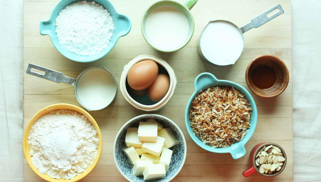 Mise en place: ingredientes para um bolo (manteiga, ovos, acúcar, amendoas, etc.) já limpos pesados e organizados em malgas.