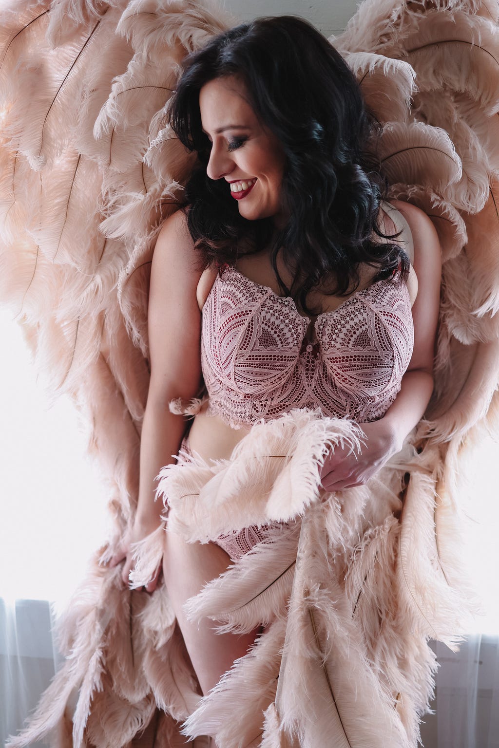 A white woman in lingerie and angel wings.