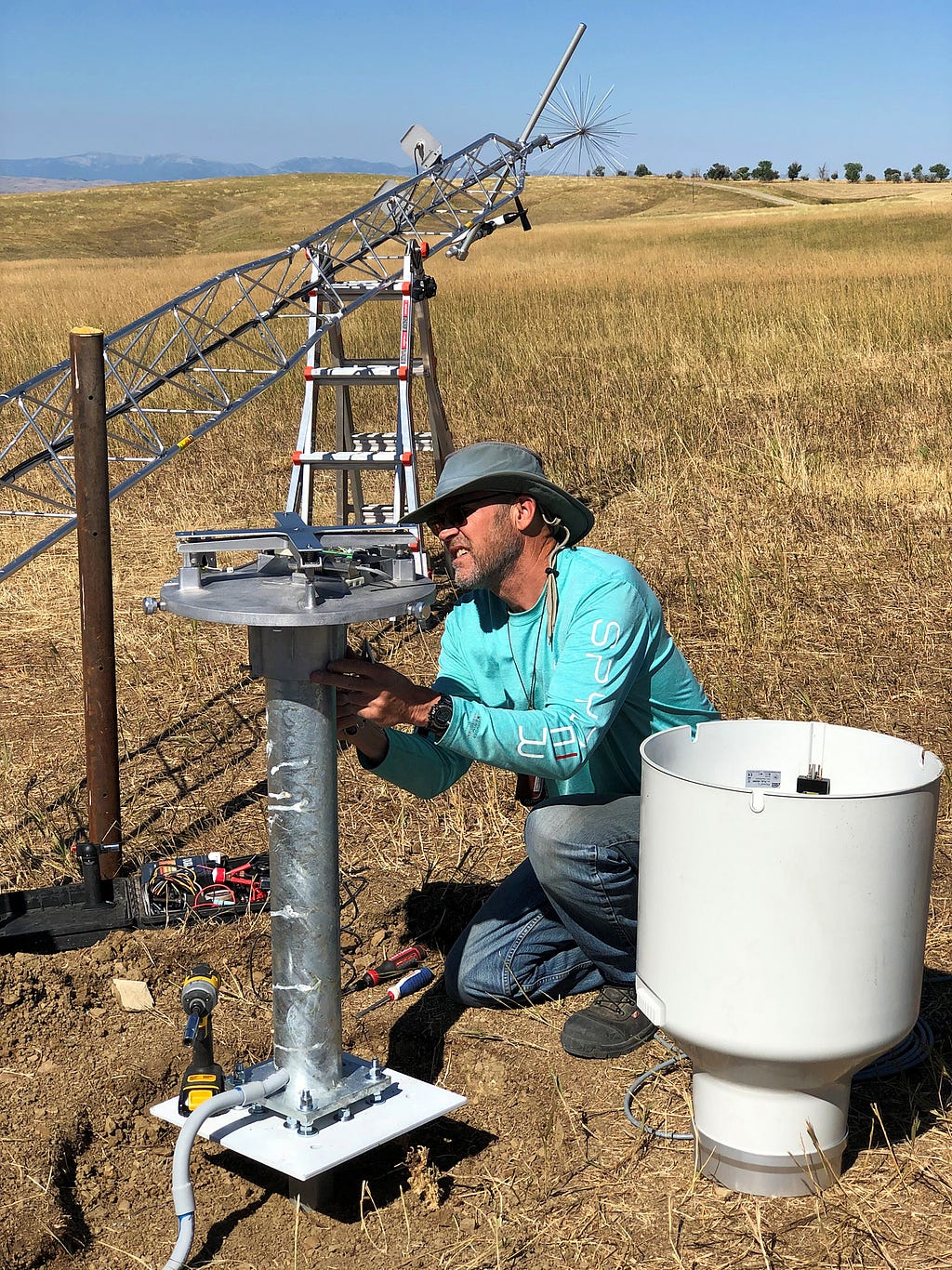 A technician wires a year-round precipitation gauge.