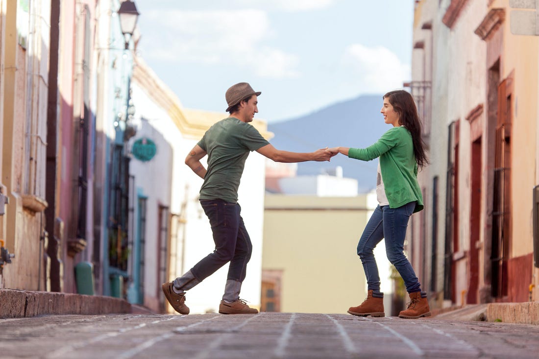 woman and man dancing in the street