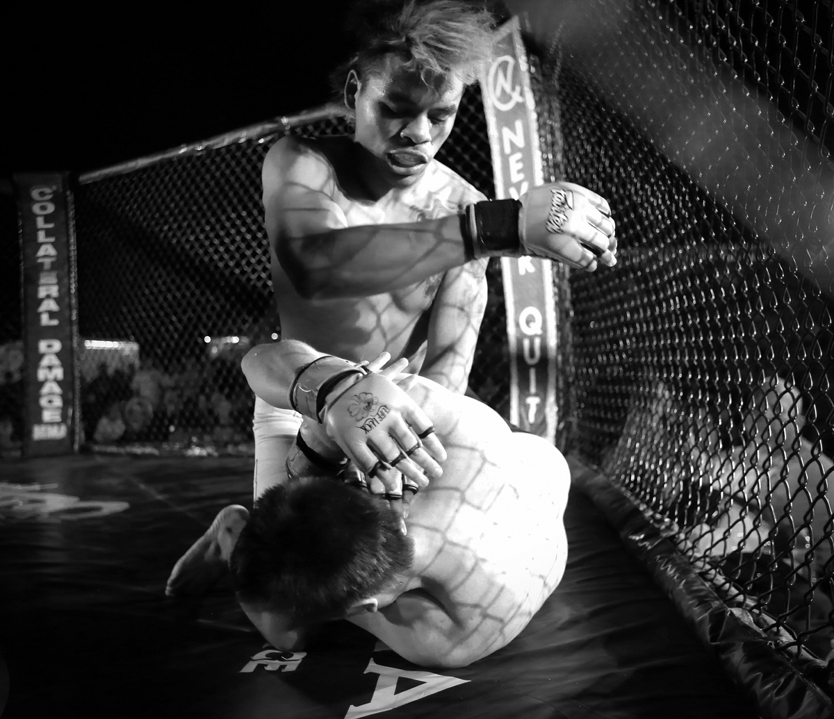 Chris “Taco” Padilla, fighter, Hardbody MMA, strikes Kenny Wyckoff, fighter, Fight Ugly MMA, during Summer Fight Night V at Del Valle Field, June 20, 2014 via Wikimedia Commons