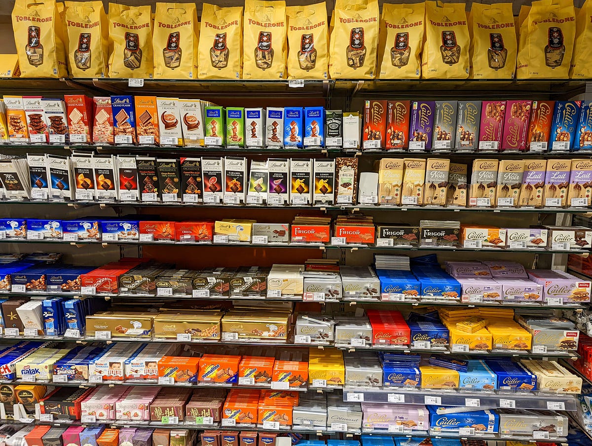 Store shelves overflowing with many bars of Swiss chocolate. So many tasty things to choose from! Where to start?