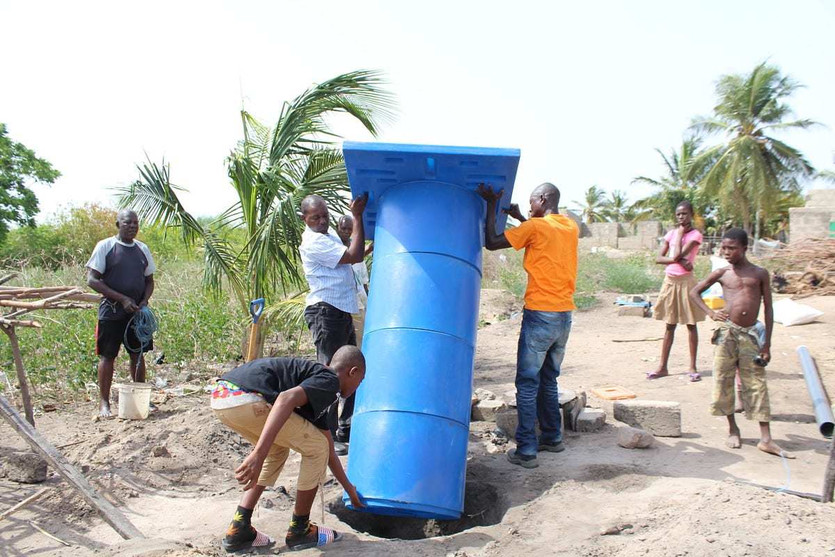 A family works together to install their new Digni-Loo. The entire installation process only takes about 10 minutes. (Melissa Burnes, USAID WASH for Health)