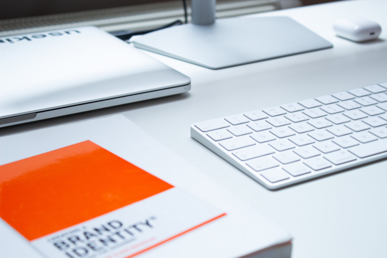 A brand identity book and a keyboard on a white table