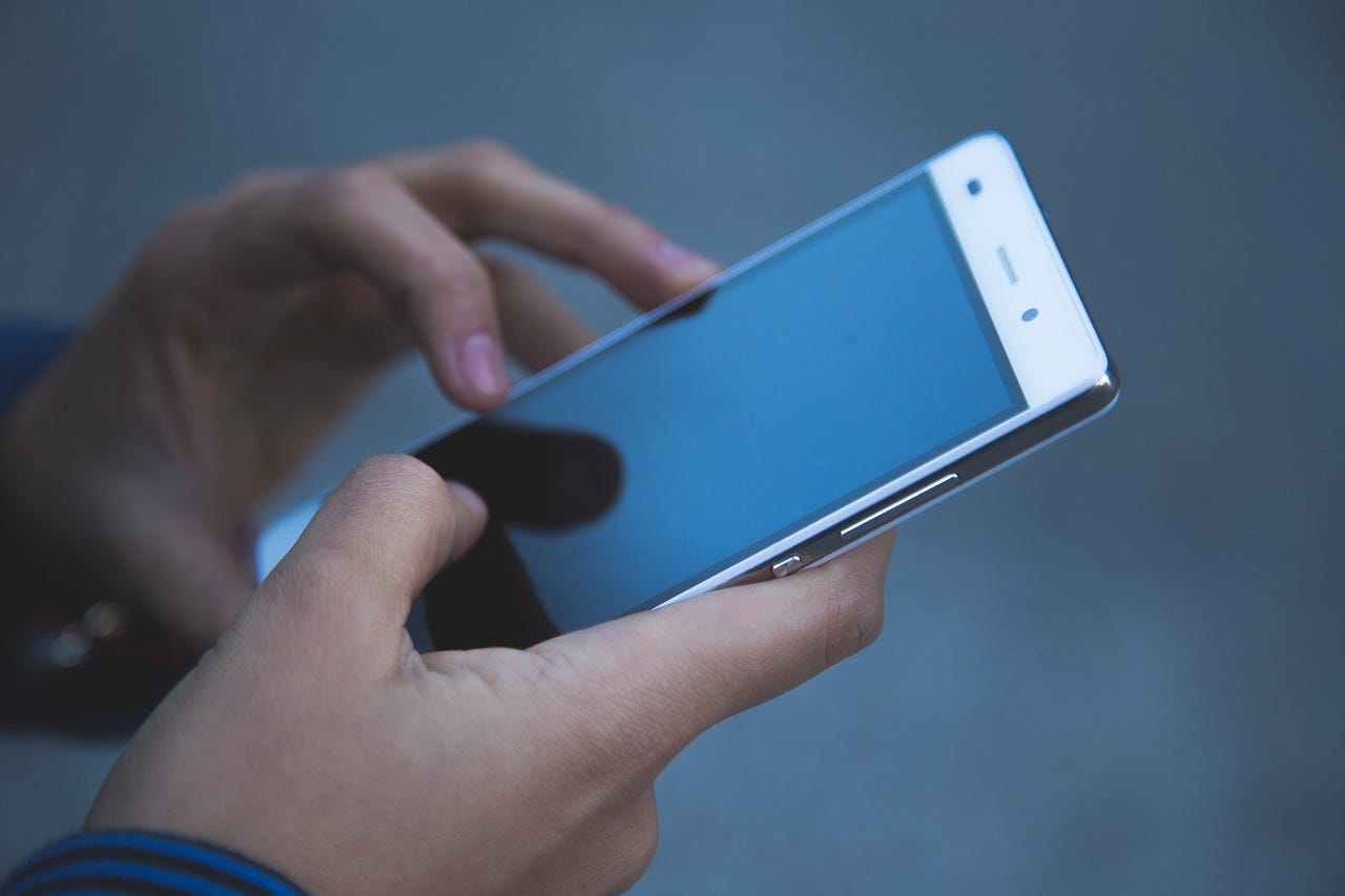 Hands holding a smartphone, symbolizing the power of staying connected with friends and family, no matter the distance — because meaningful relationships are just a tap away in today’s digital age.