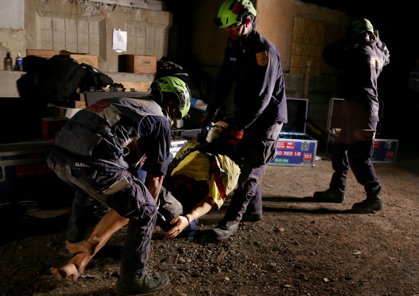 Members of Red Squad One, an urban search and rescue team out of Fairfax County Fire and Rescue Department, rescue a “victim” trapped under a collapsed concrete building during the first night of their annual week-long exercise put on by USAID. / Emily Rasinski, USAID/OFDA