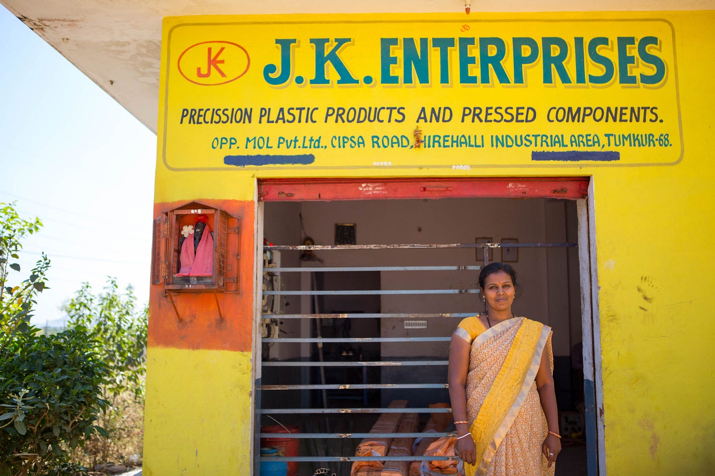 Vanaja stands in front of her manufacturing business in India