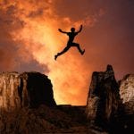 Silhouette of a man leaping across a chasm