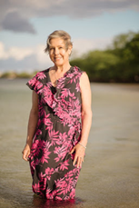 Woman in Hawaiian dress in water at beach