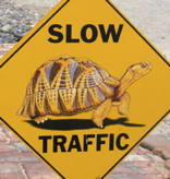 yellow diamond traffic sign with black text and brown and yellow turtle