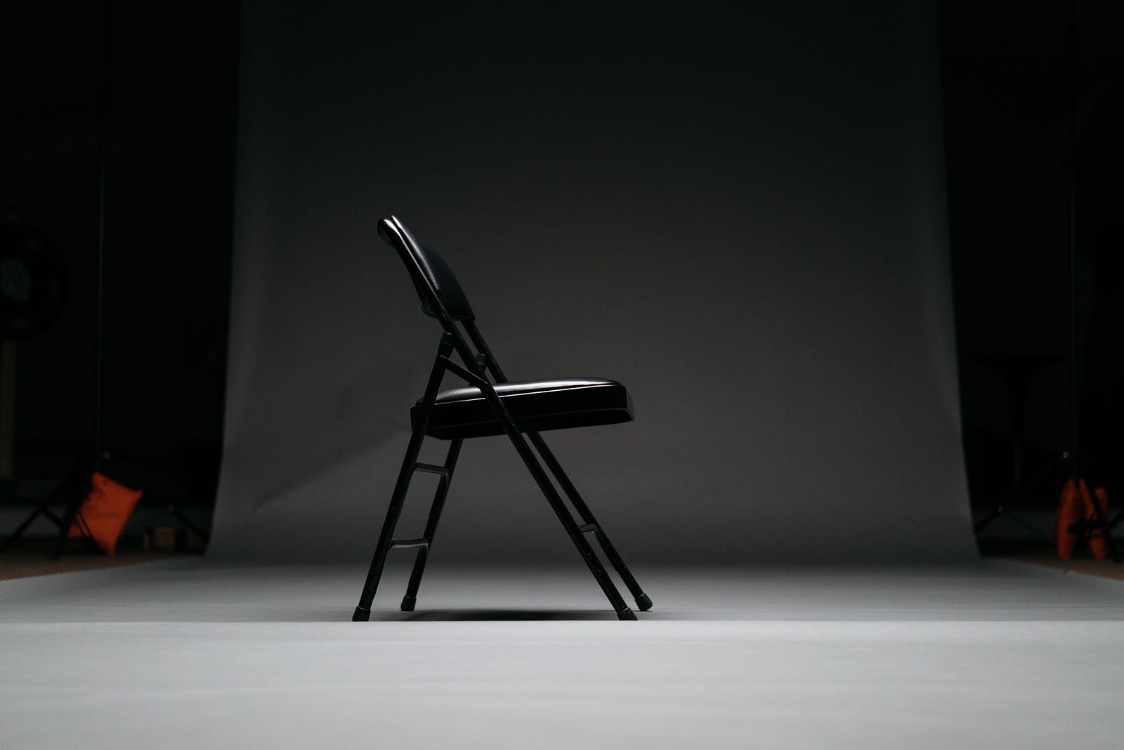 A black folding chair, seen in profile in an otherwise empty room. Yoga can improve gait speed and leg strenth, accfording to a new clinical trial.