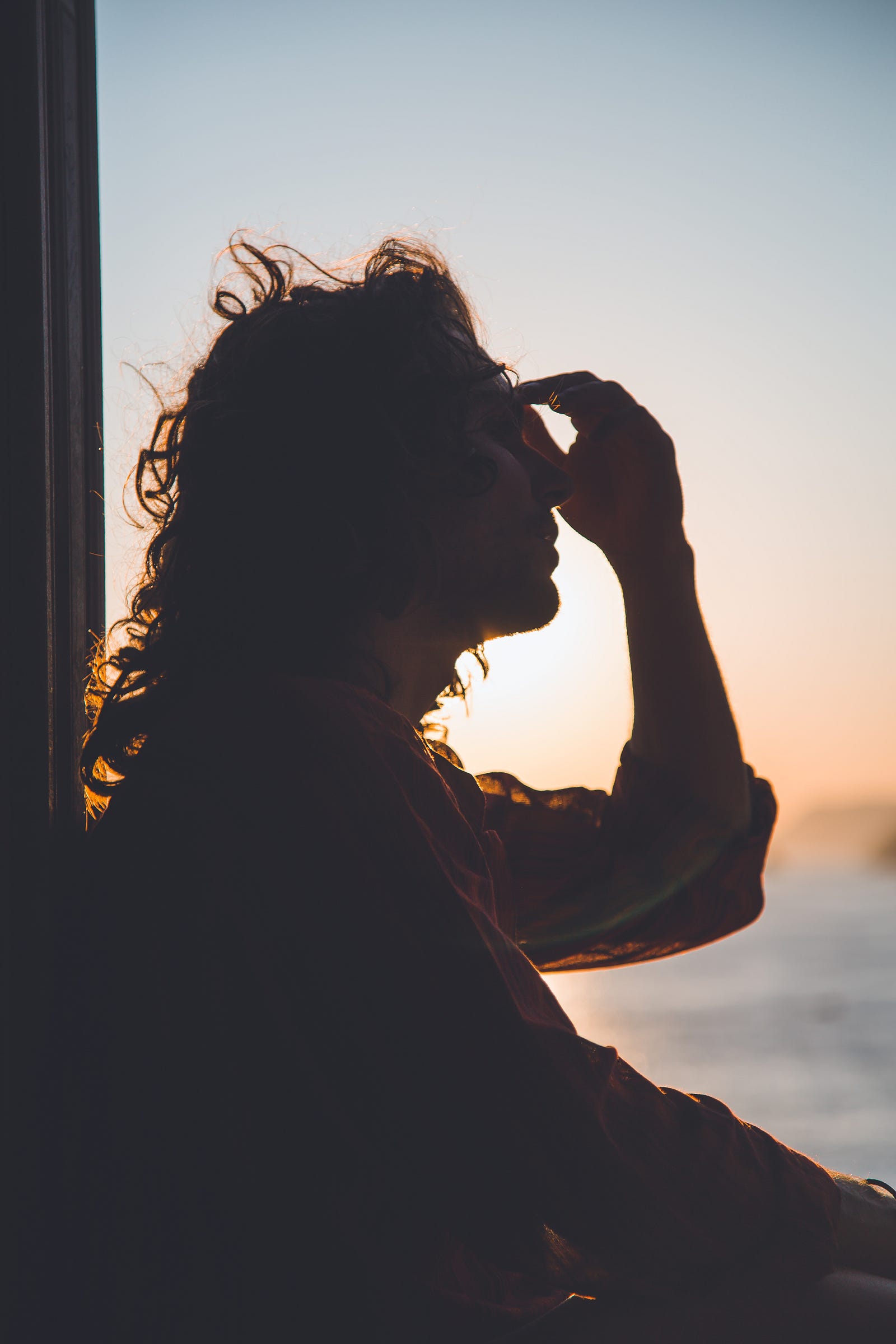 A woman is seen in profile, her left hand touching her forehead. Pollutants such as carbon monoxide can cause headaches or dizziness. Occasionally, an individual may experience nausea or pass out from air pollution.