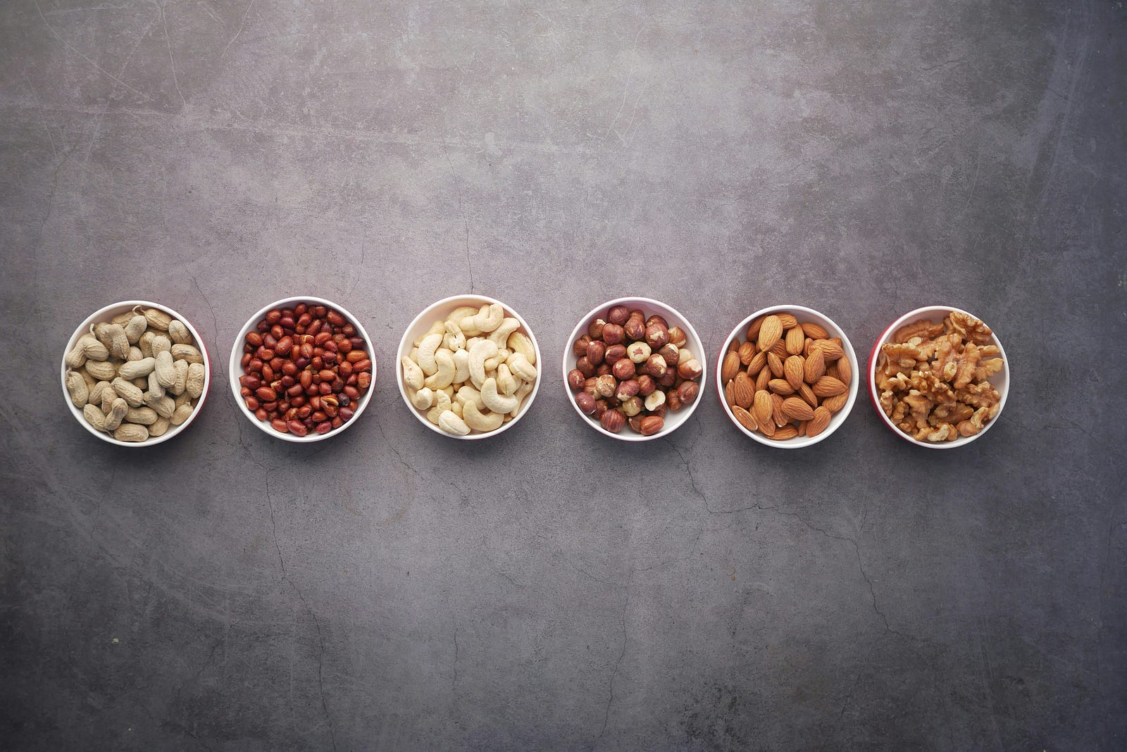 Small bowls of nuts, lined up horizontally.