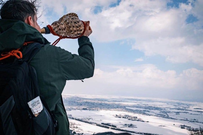 A yamabushi blowing his horagai conch from Mt. Kinbo