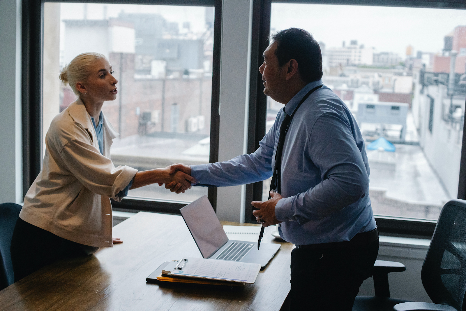 two office workers shaking hands