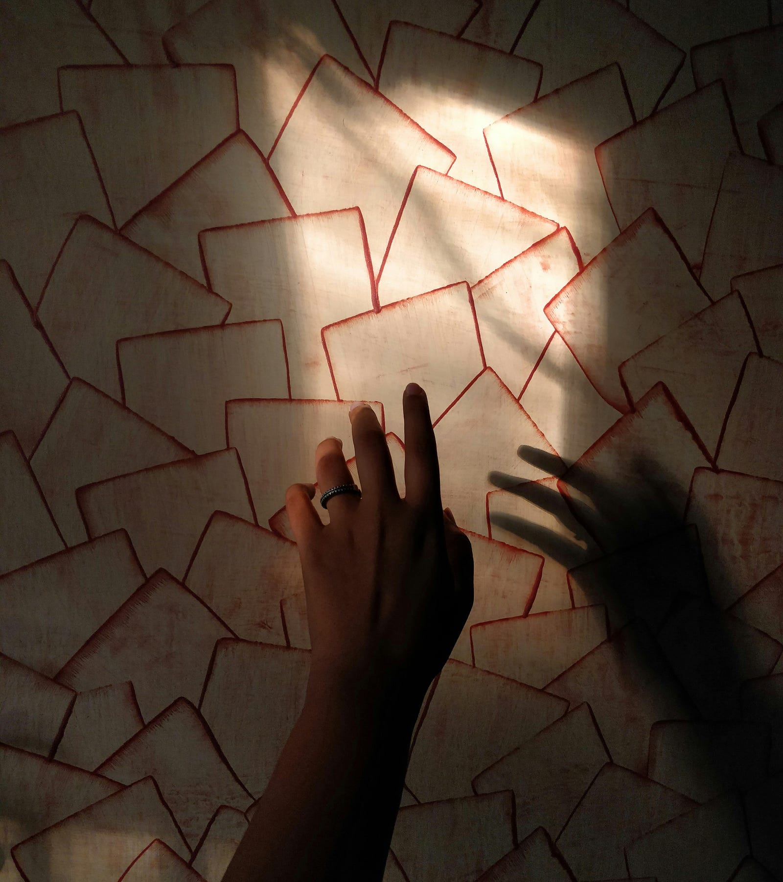 Two hands reach towards a wall of overlapping squares.