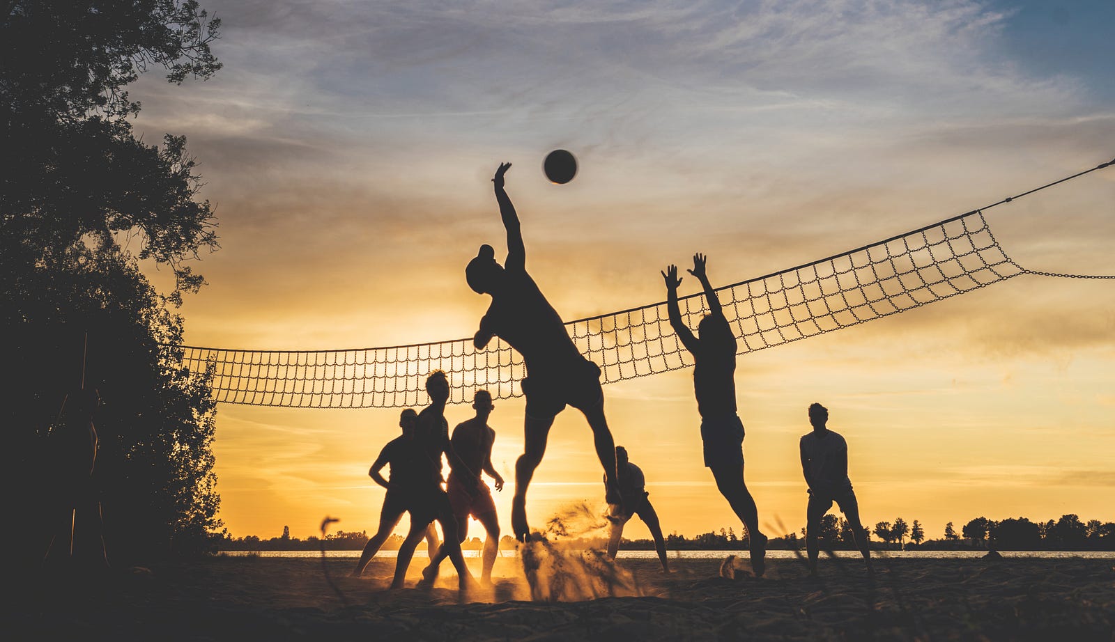 Eight individuals play volleyball. We see someone spiking the ball. All are in silhouette, with a lovely sunrise in the background. An important part of my master’s bodybuilding (perhaps physique optimization is a more descriptive term) is listening to my body. When I was younger, I often thought I could train through minor injuries. I no longer think that way.