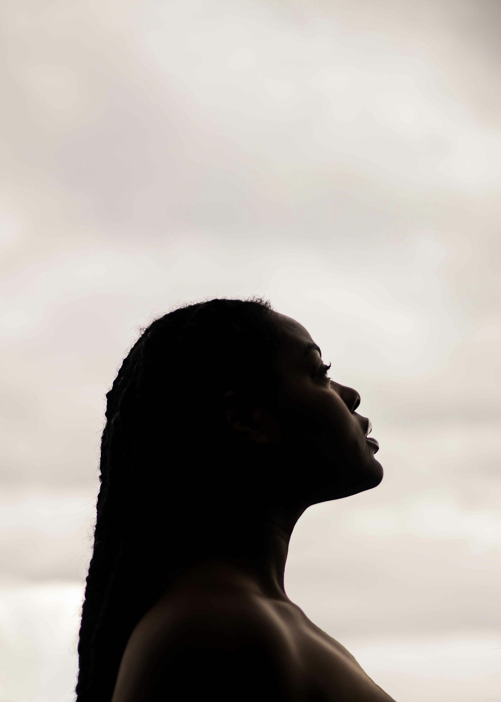 A young black woman in profile/silhouette. Coffee appears to lower ovarian cancer risk.