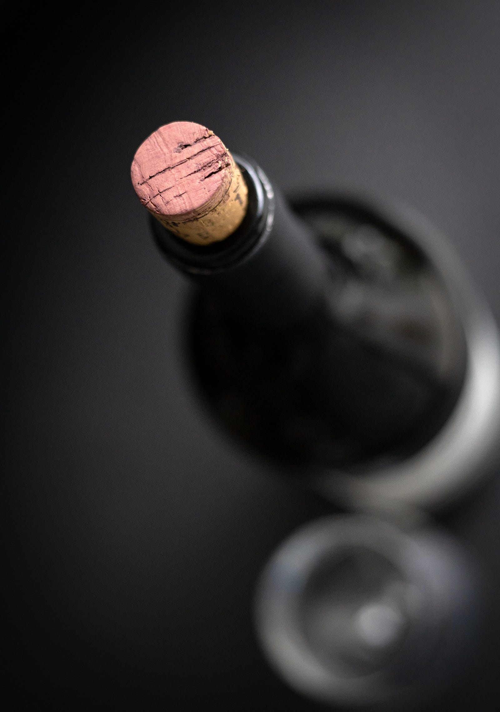 A glass of wine from above, cork in place. In its Report on Carcinogens, the National Toxicology Program of the US Department of Health and Human Services lists the consumption of alcoholic beverages as a known human cancer-causing agent.