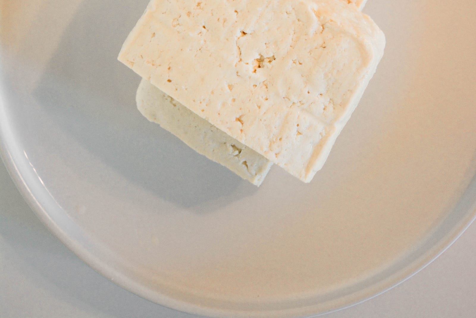 A white plate with two stacked rectangular pieces of tofu.Incorporating soy foods into your diet can promote health.