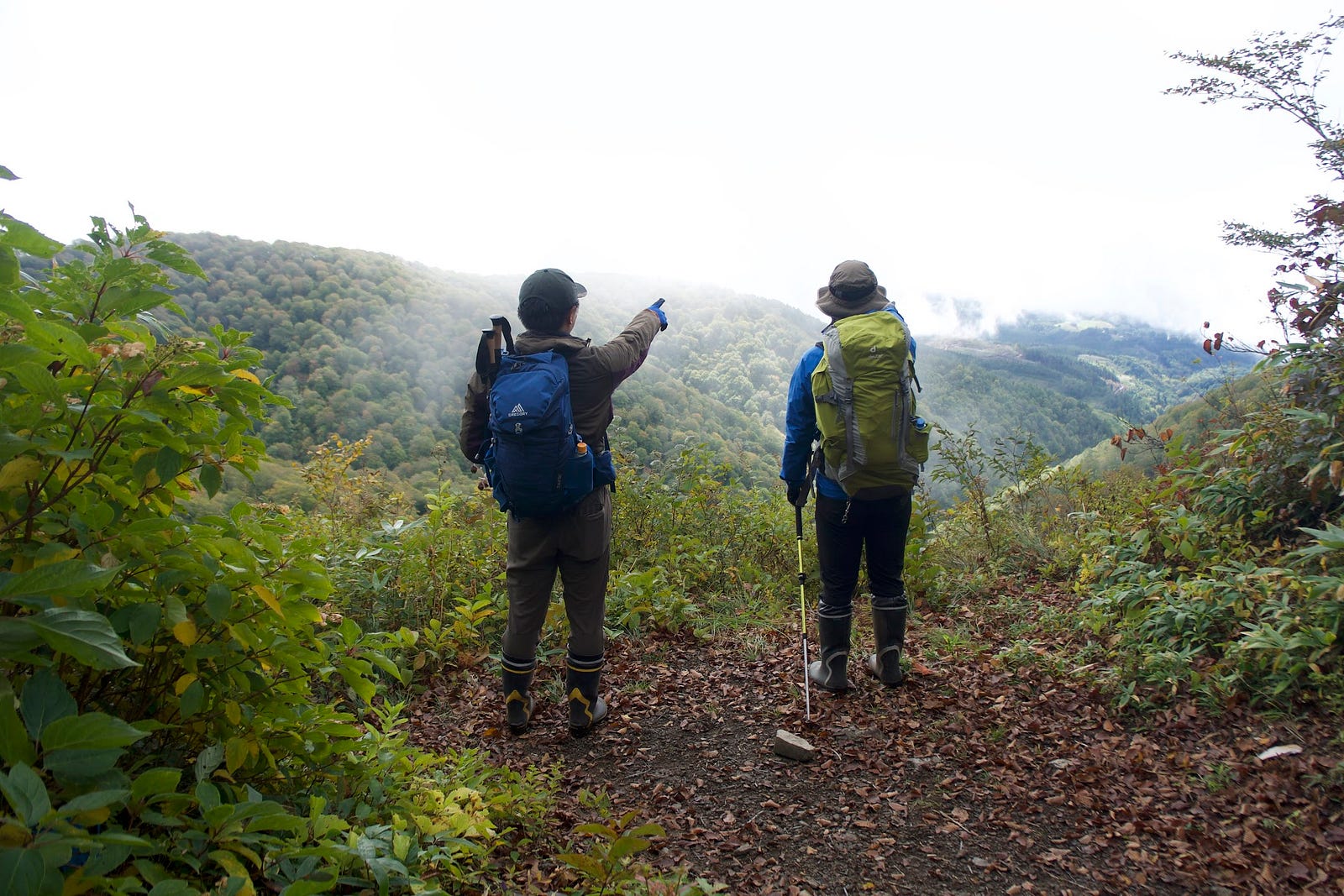 Hikers point into what appears to be white cloud during their hike up Murayama Ha-yama