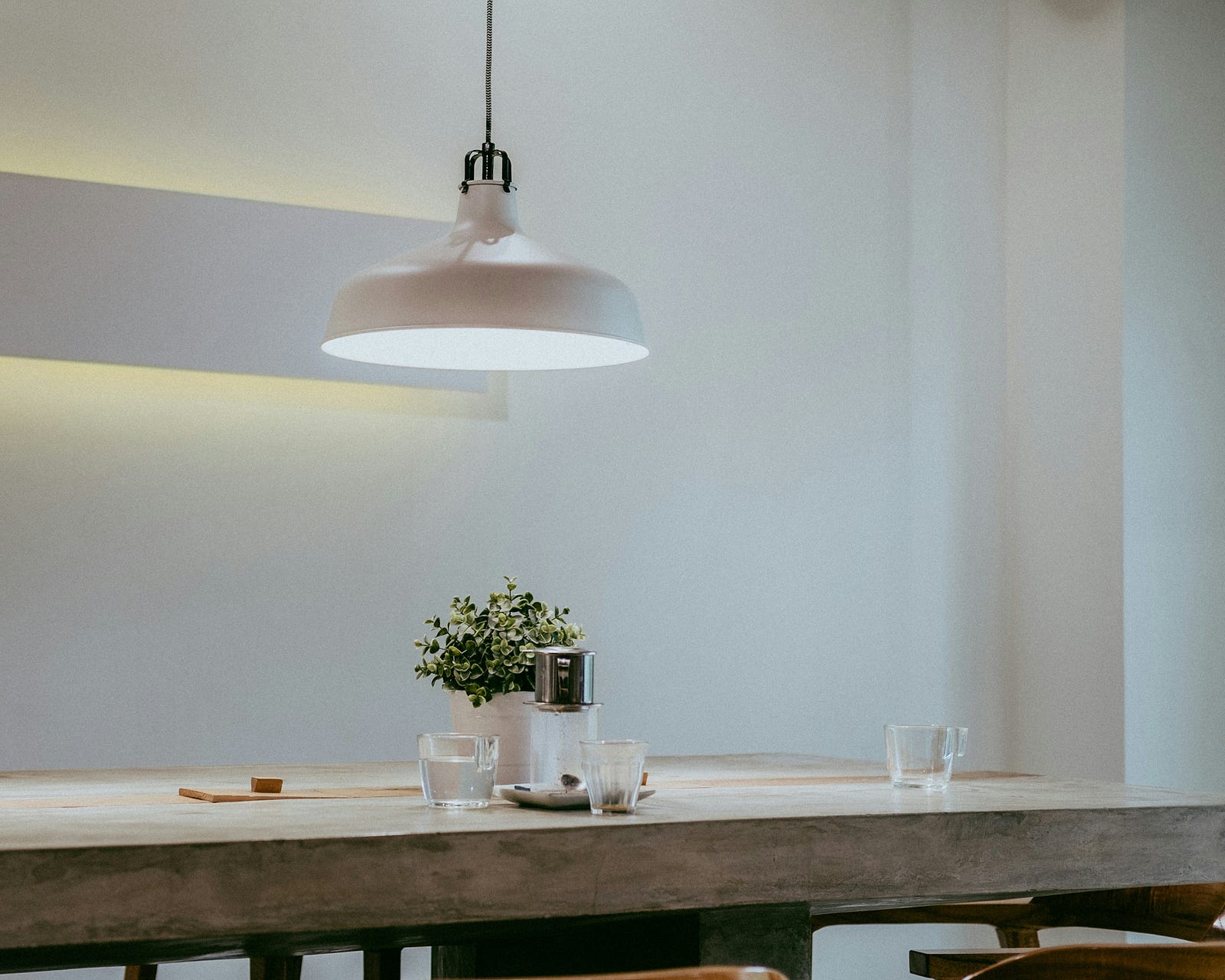 A kitchen table made of rough wood with a single hanging light above it. Brightening your home with stronger light bulbs or additional lighting can reduce the probability of falls.