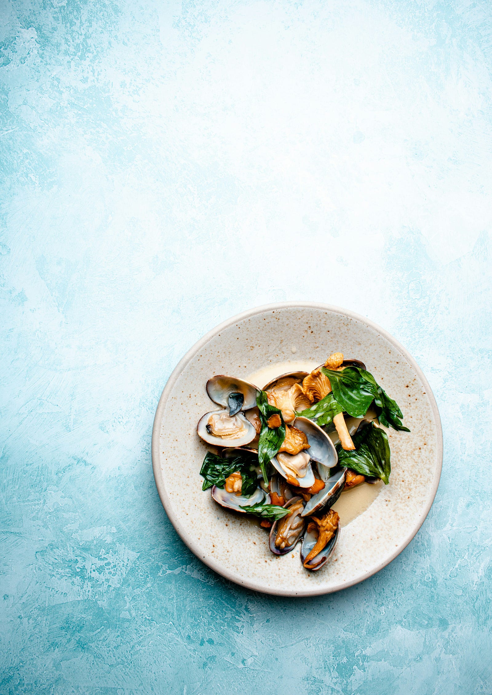 Clams on a dinner plate. Aquatic foods (including clams, crabs, shrimp, salmon, trout, cod, and more) can be excellent sources of folate. Photo by Edward Howell on Unsplash.