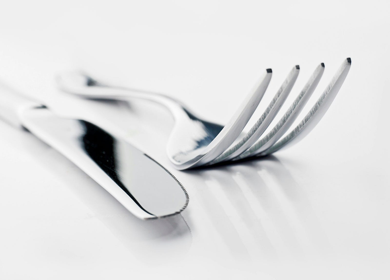 A fork and a knife seen in close-up. The image is in black and white.