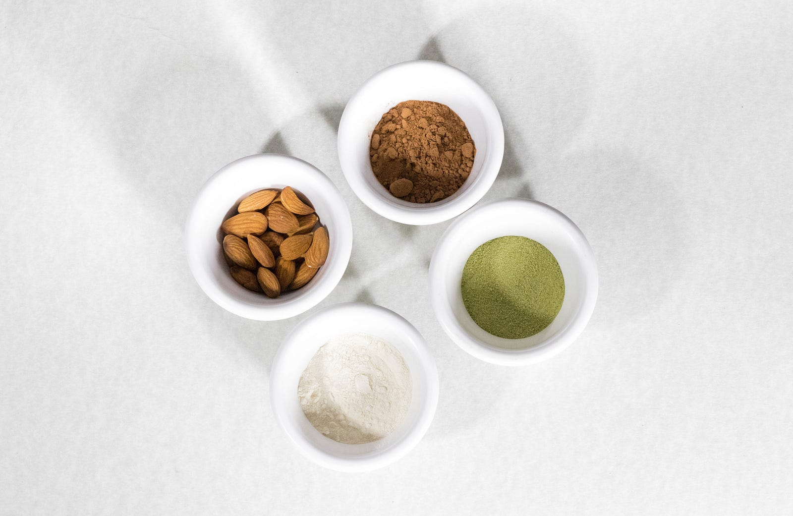 Four small white bowls, one containing almonds. The other three have poders, colored white, green, and brown. Almonds are the tree nut with the most vitamin E, with 7.7 milligrams (mg) in every 30-gram serving. In addition, a serving of almonds has 80 mg of calcium and 0.3 mg of riboflavin.